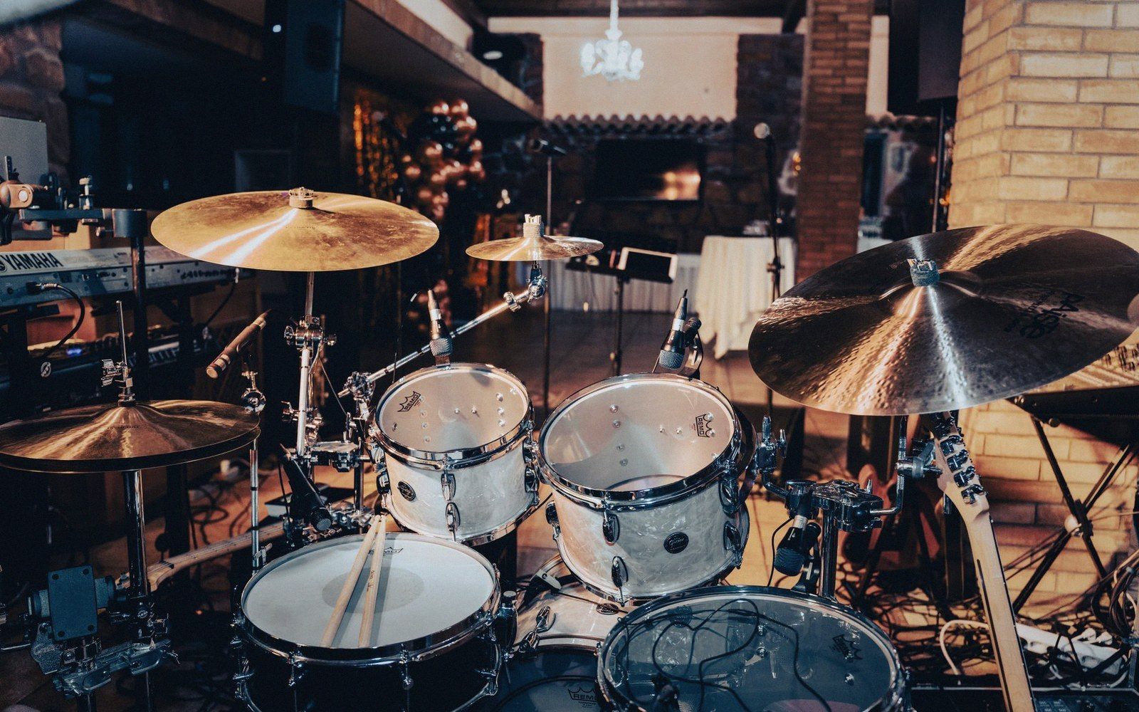 Drum kit with cymbals and mounted toms set up on a stage before a venue