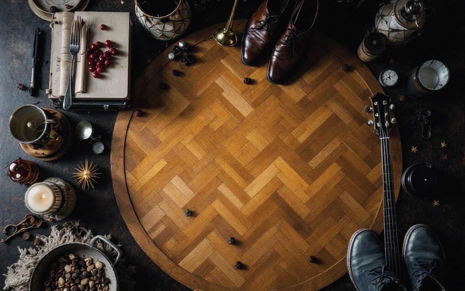 Overhead view of a herringbone wood floor circle surrounded by shoes, guitar and candles