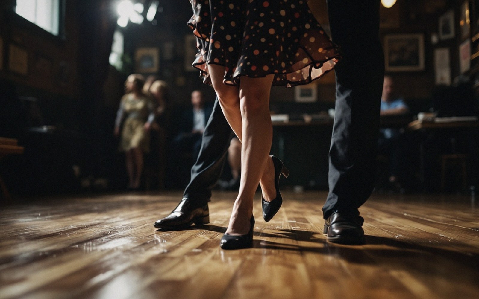 A close-up of a couple's legs and shoes dancing on a wooden floor