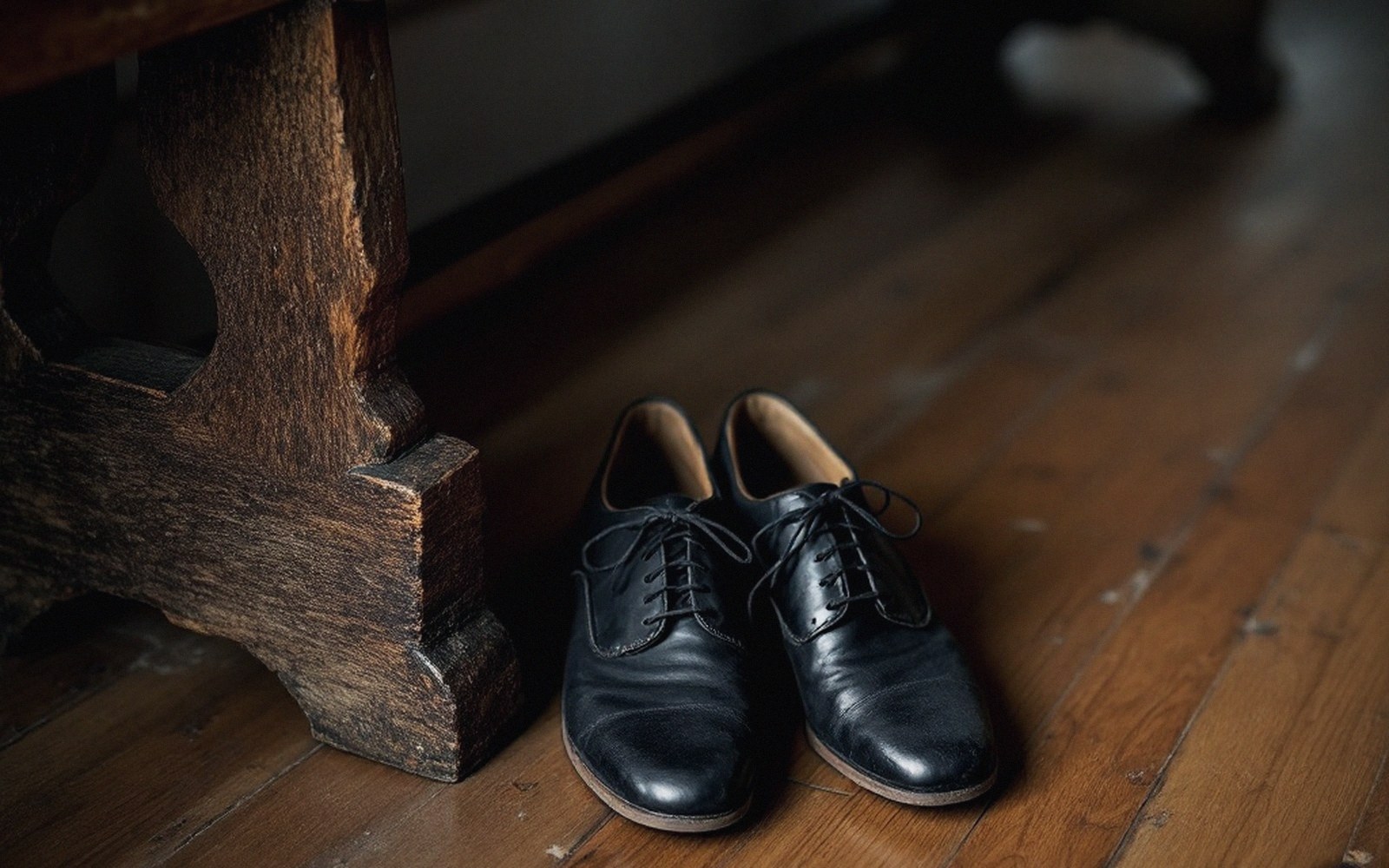 Dance shoes and a bench at the edge of a hall, suede soles worn, bags underneath